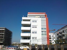 Ein großes weißes Gebäude mit rotem Dach ist im Bau.