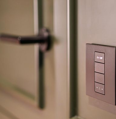 A close up of a light switch on a wall next to a door.
