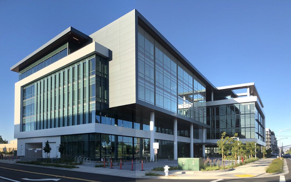 A large building with a lot of windows and a fire hydrant in front of it.