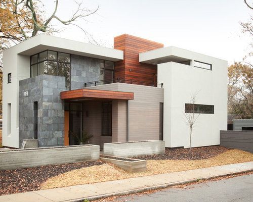 A modern house is sitting on the side of a street.