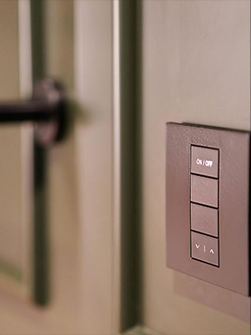 A close up of a light switch on a wall next to a door handle.
