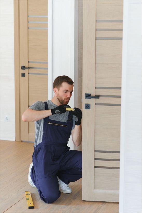 A man is measuring a door with a tape measure.
