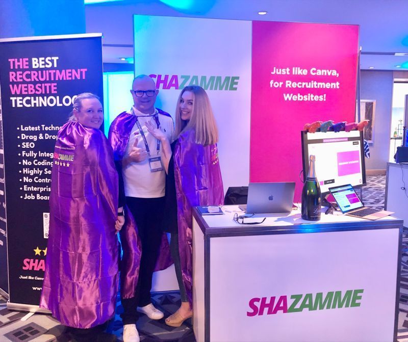 Three people at a booth with a 