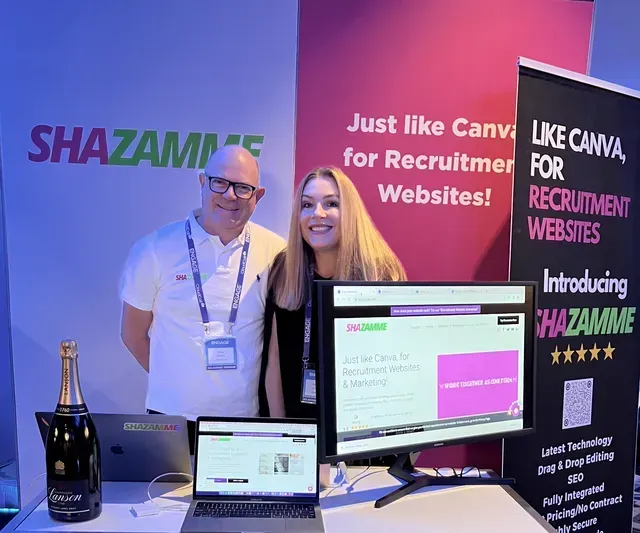 Two people at a booth promoting