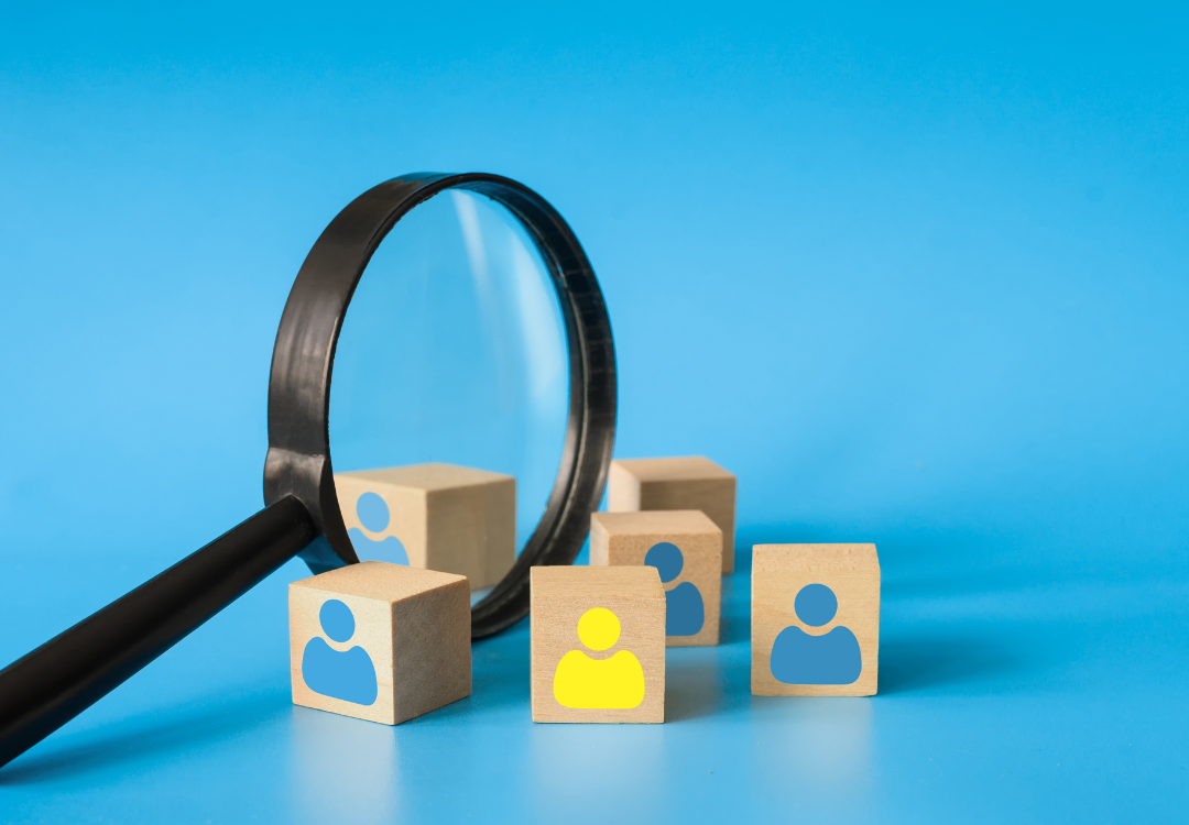 Person using a smartphone with email icons overlaying, near an open laptop in a cafe.