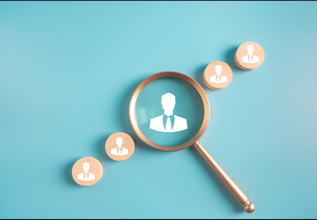 Person using a smartphone with email icons overlaying, near an open laptop in a cafe.