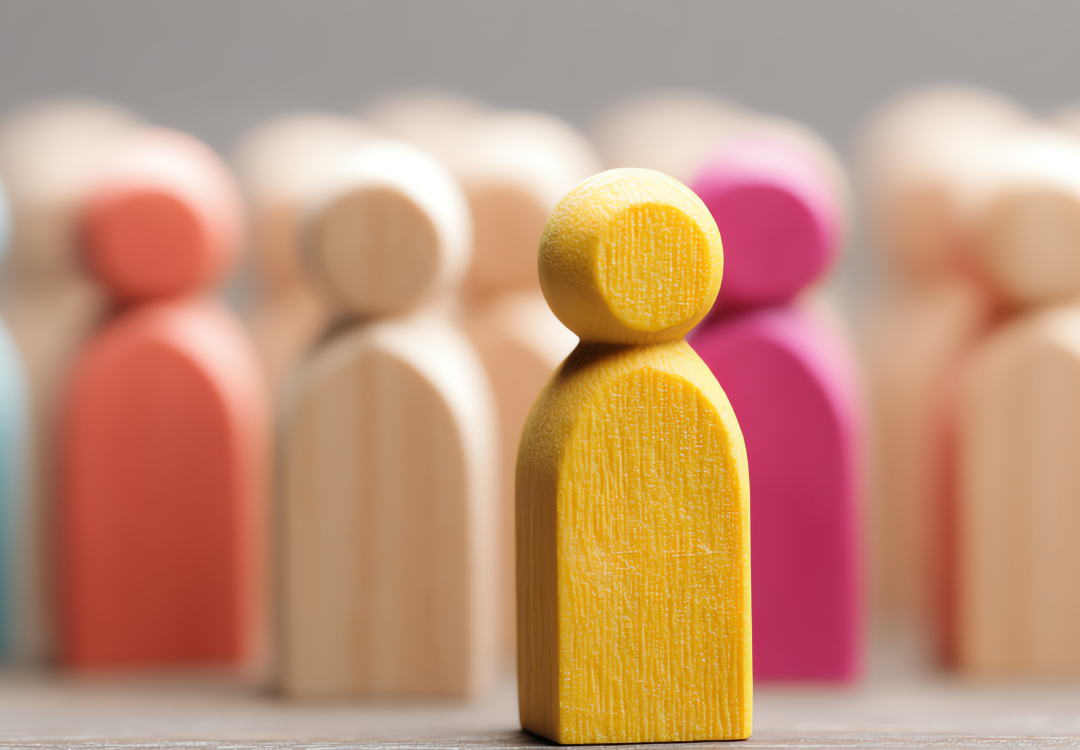 Person using a smartphone with email icons overlaying, near an open laptop in a cafe.