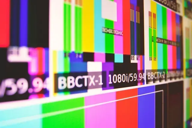 A close-up of a colorful BBC broadcast test pattern on a screen, including black and white boxes and color bars.