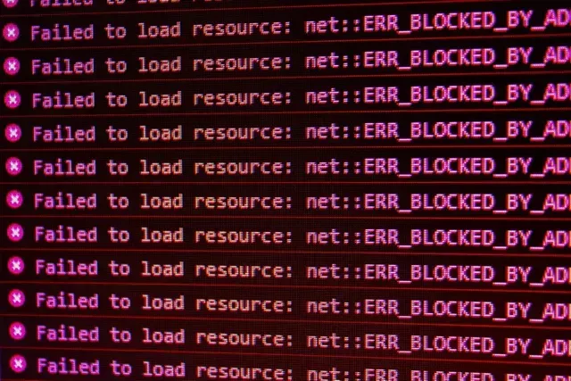Error messages on a screen indicating resources blocked by an ad blocker, with pink text on a dark background.