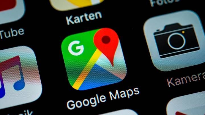 Google Maps app icon on a smartphone screen. Green, red, and yellow logo with the word 