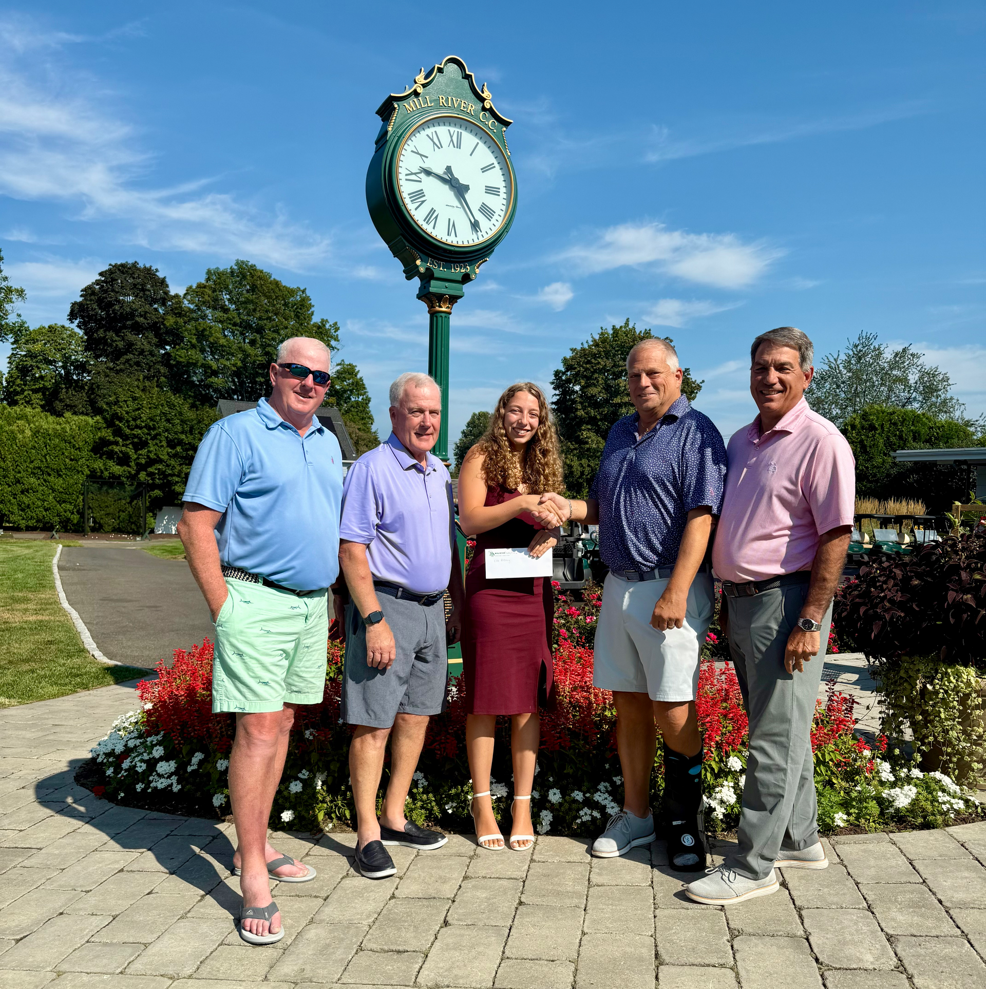 A group of people are walking on a golf course.