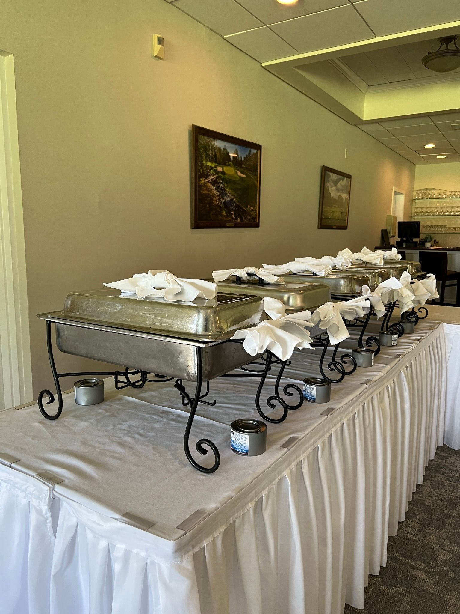 A long table with a lot of trays of food on it.