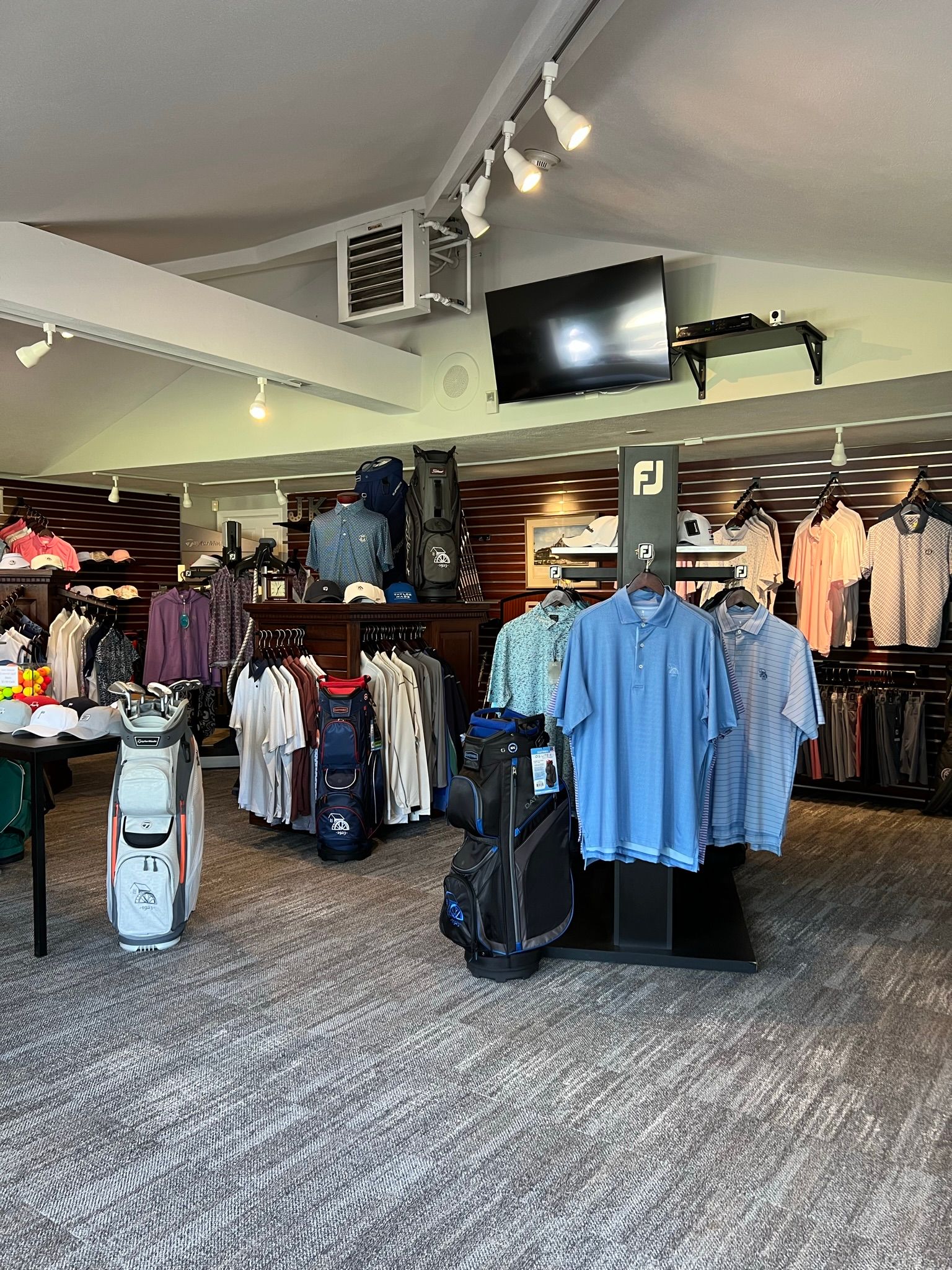 A large room filled with lots of clothes and golf bags.