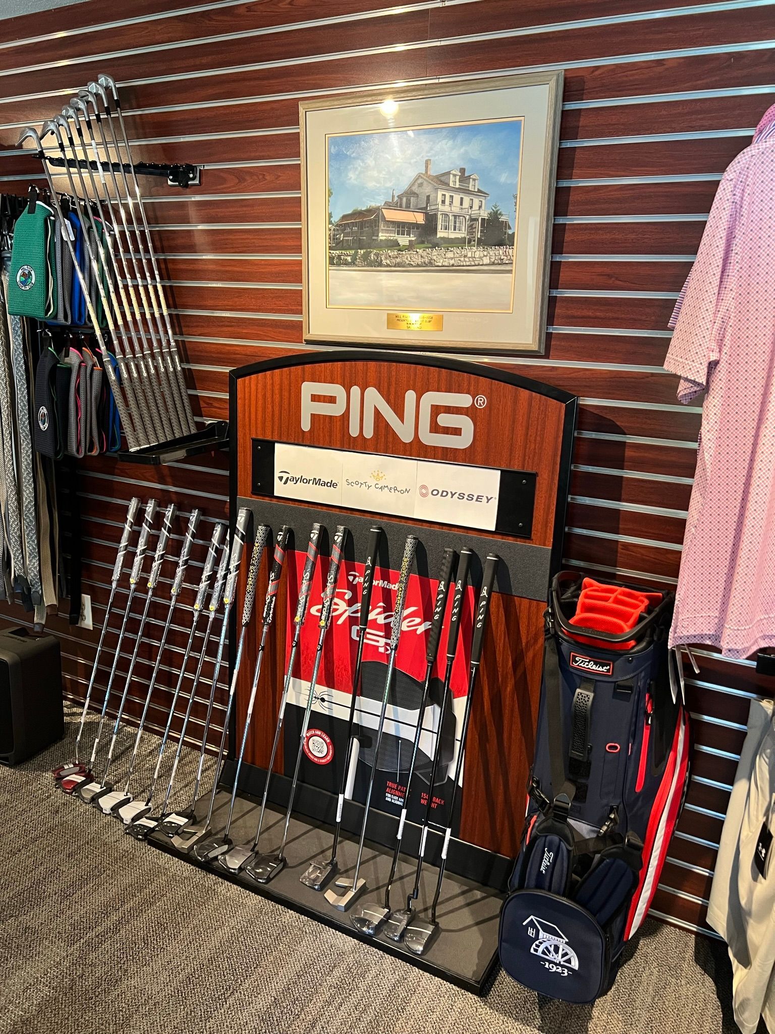 A ping golf display in a store with a picture on the wall.