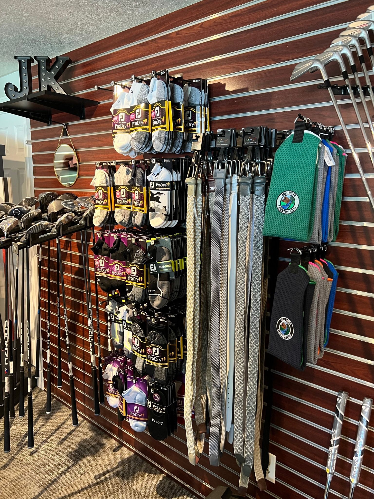 A store filled with lots of belts and hats hanging on a wall.