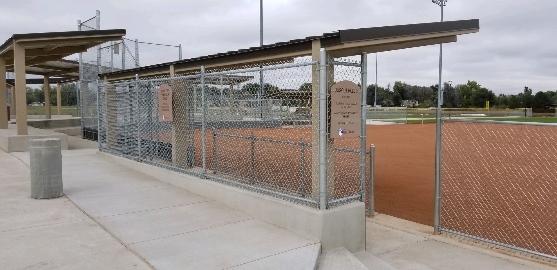 A baseball field with a chain link fence buit by Greater Western Fence surrounding it