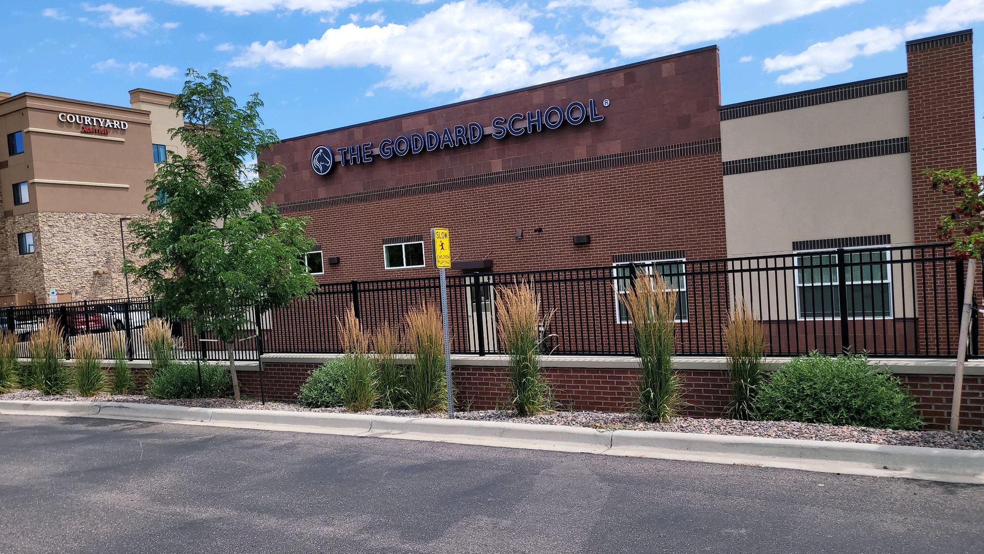 A large brick building with a fence built by Greater Western Fencein front of it