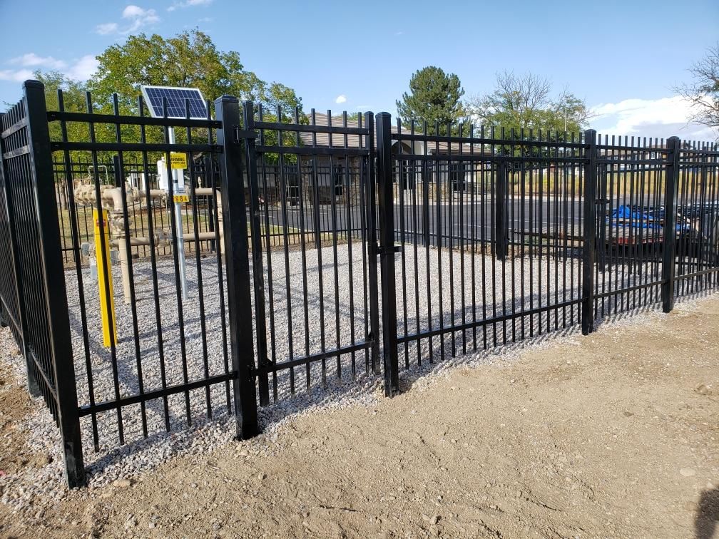 A black metal fence built by Greater Western Fence has a solar panel on top of it.