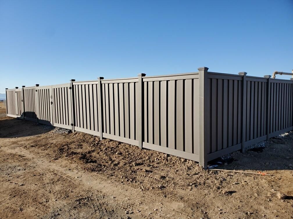 A fence is sitting in the middle of a dirt field.