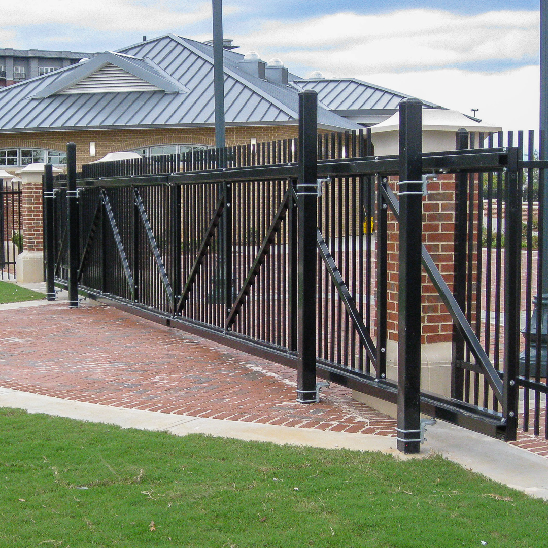 A black fence built by Greater Western Fencewith a brick building in the background