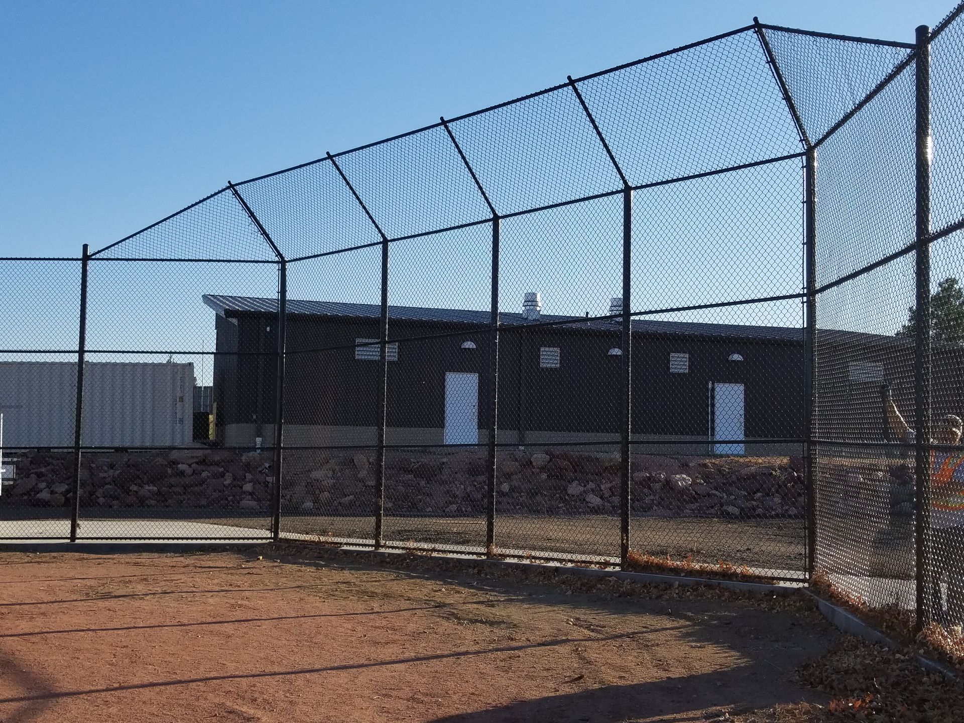 A chain link fencebuit by Greater Western Fence with a building in the background