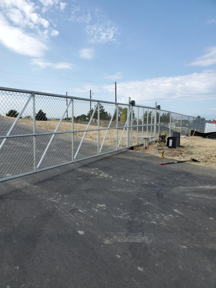 A chain link fence is sitting on the side of a road.