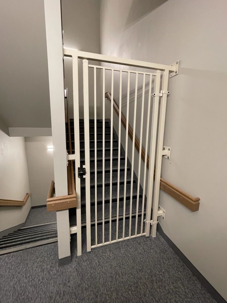 A staircase with a gate built by Greater Western Fence between it and the stairs.