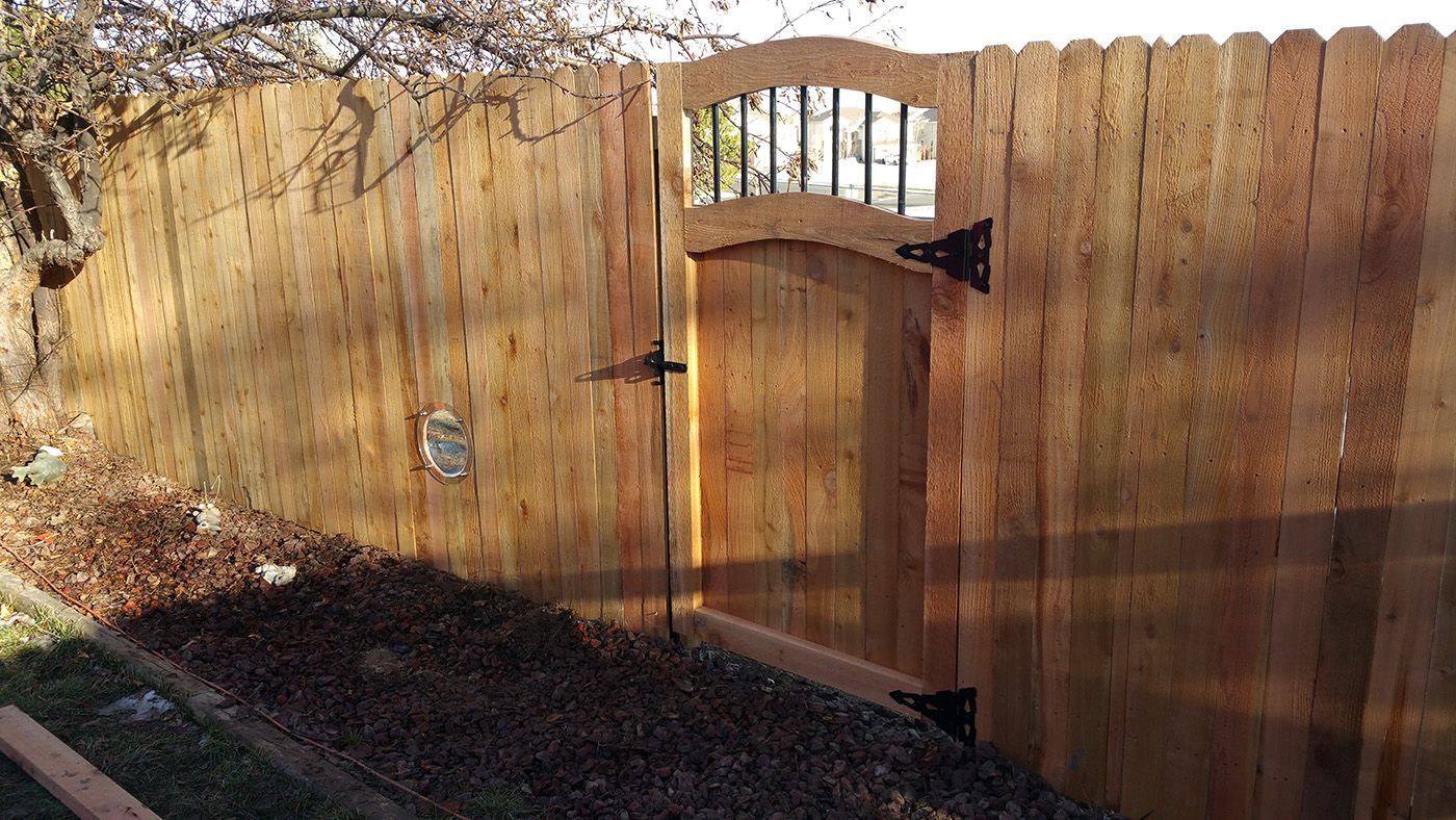 A wooden fence is built by Greater Western Fence with a gate in the middle of it.