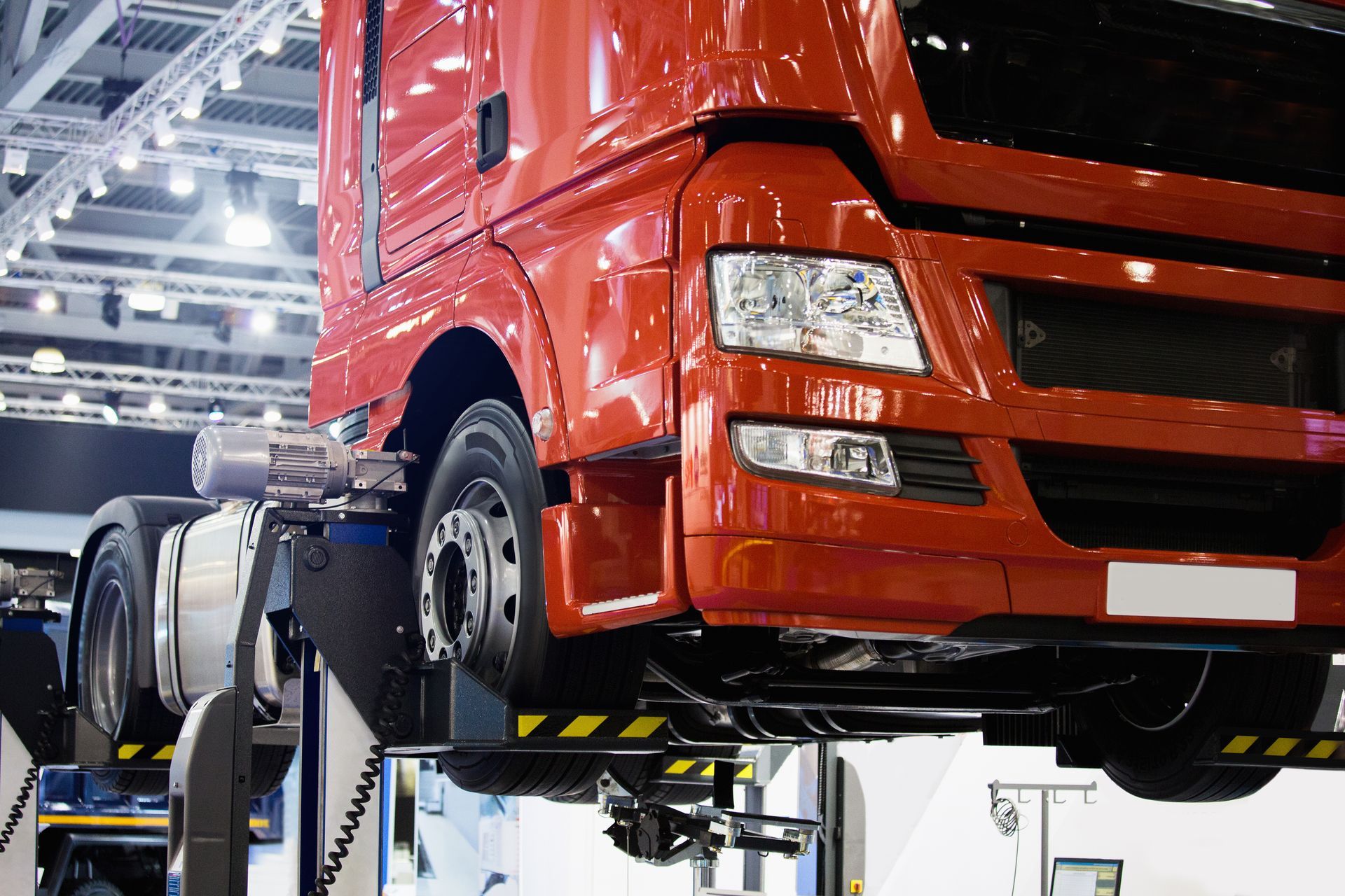 Red semi-truck on a lift in a garage