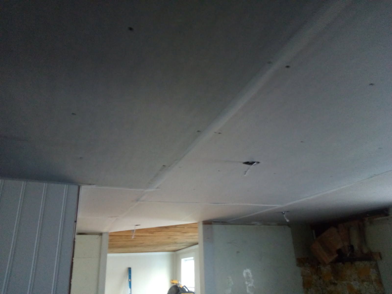 Ceiling with drywall patches and screw holes; a room under renovation.