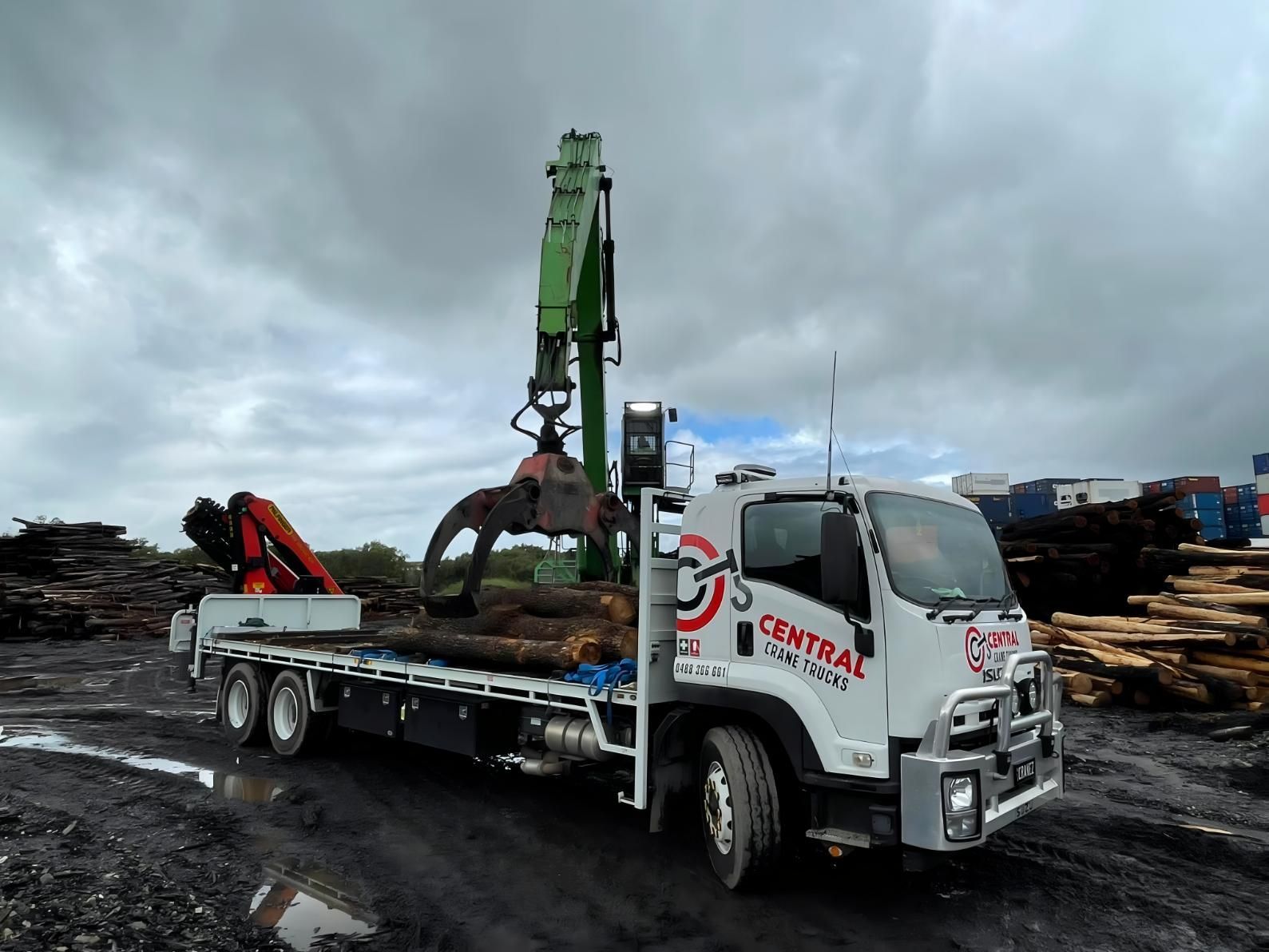 A Truck With a Crane on the Back is Parked in a Lot of Logs — Central Crane Trucks In Gold Coast, QLD