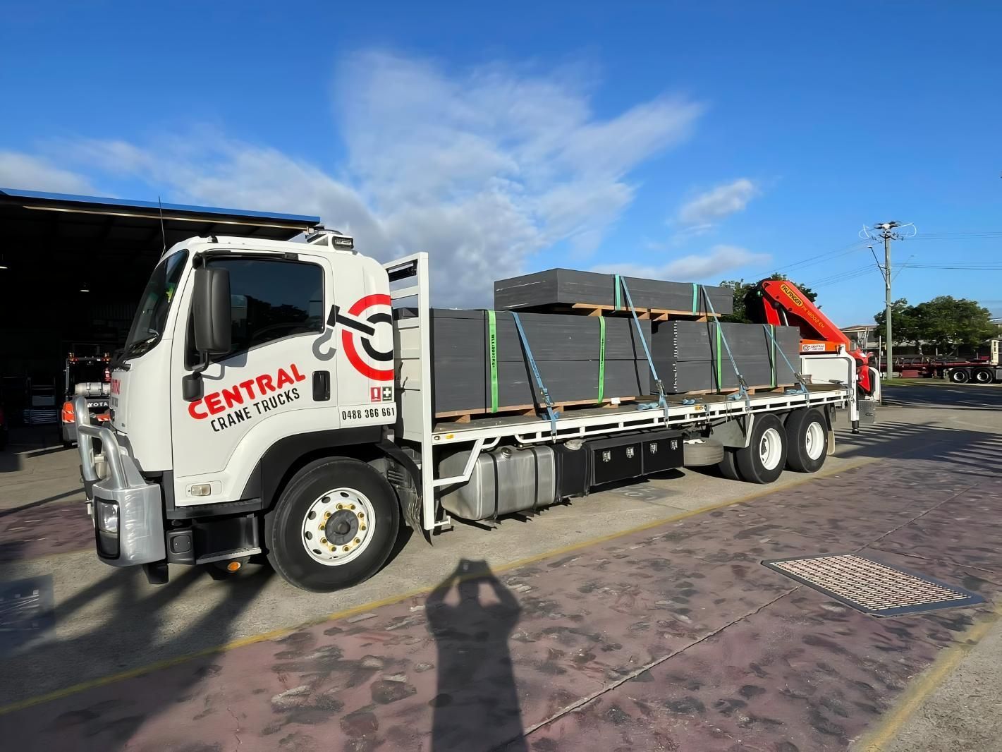 A White Truck With a Crane on the Back is Parked in a Parking Lot — Central Crane Trucks In Stapylton, QLD