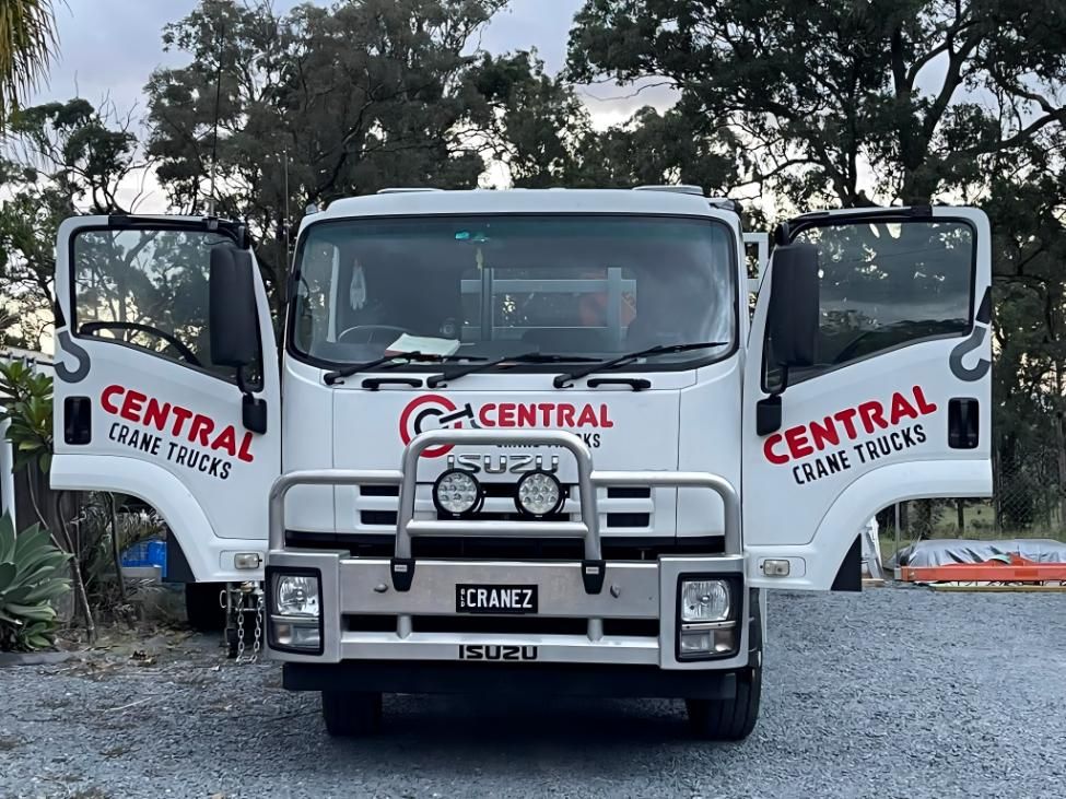 A White Truck With the Doors Open is Parked in a Gravel Lot — Central Crane Trucks In Stapylton, QLD