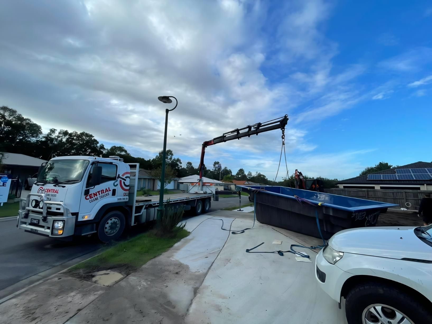 A Truck With a Crane Attached to It is Carrying a Swimming Pool — Central Crane Trucks In Stapylton, QLD