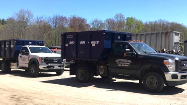 Two dump trucks are parked next to each other in a parking lot