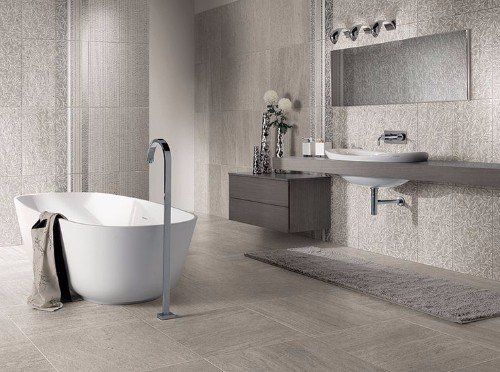 un bagno con una vasca, un lavabo e delle piastrelle di color grigio