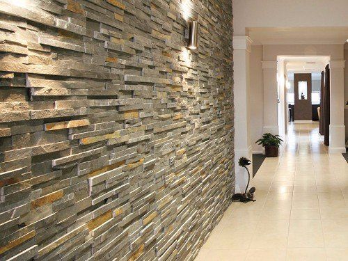 un corridoio lungo con pavimento in piastrelle di color avorio e un muro con le piastrelle a effetto pietra