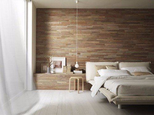 una camera con un letto e il  muro dietro con piastrelle a sfumature marroni