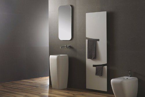 un bagno con un lavabo alto e uno specchio al muro