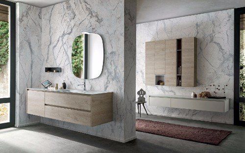 un bagno con i mobili in legno chiaro e pareti in marmo
