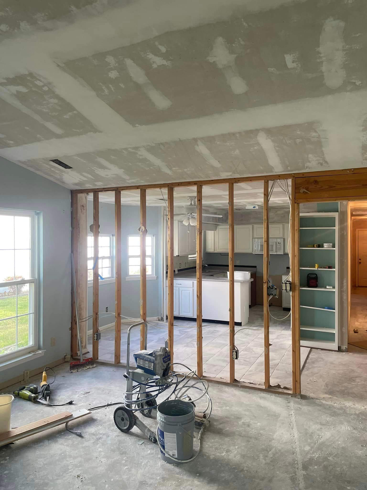 A room that is being remodeled with a bucket of paint on the floor.