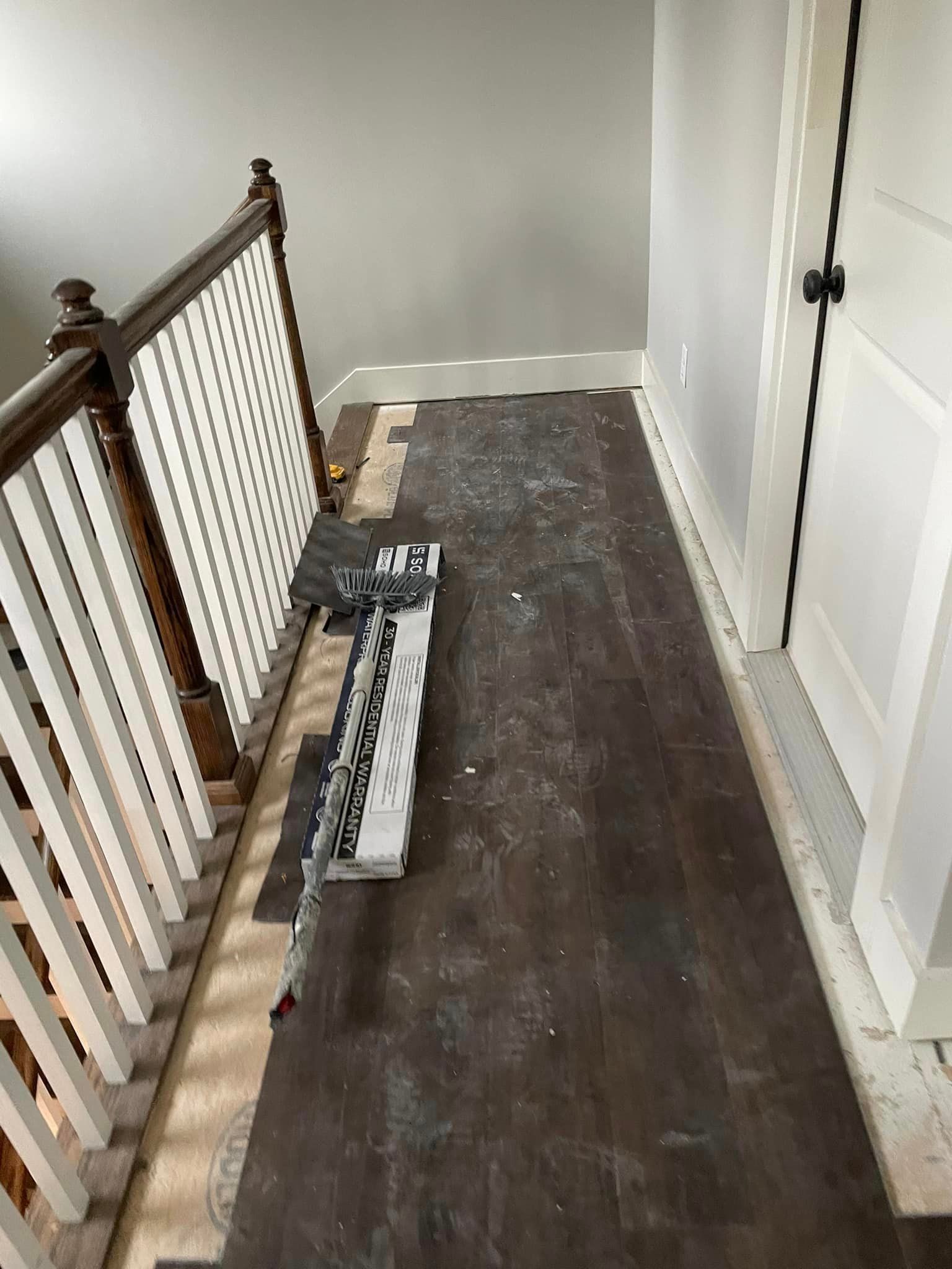 A hallway with a wooden railing and a wooden floor.
