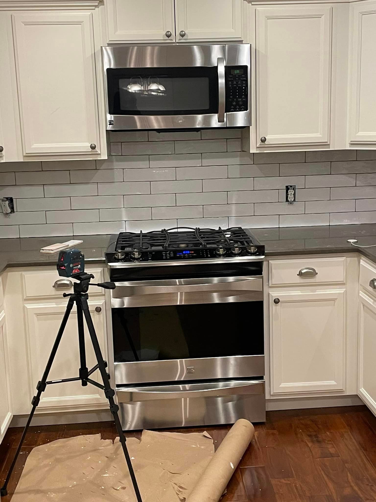 A kitchen with stainless steel appliances and white cabinets.