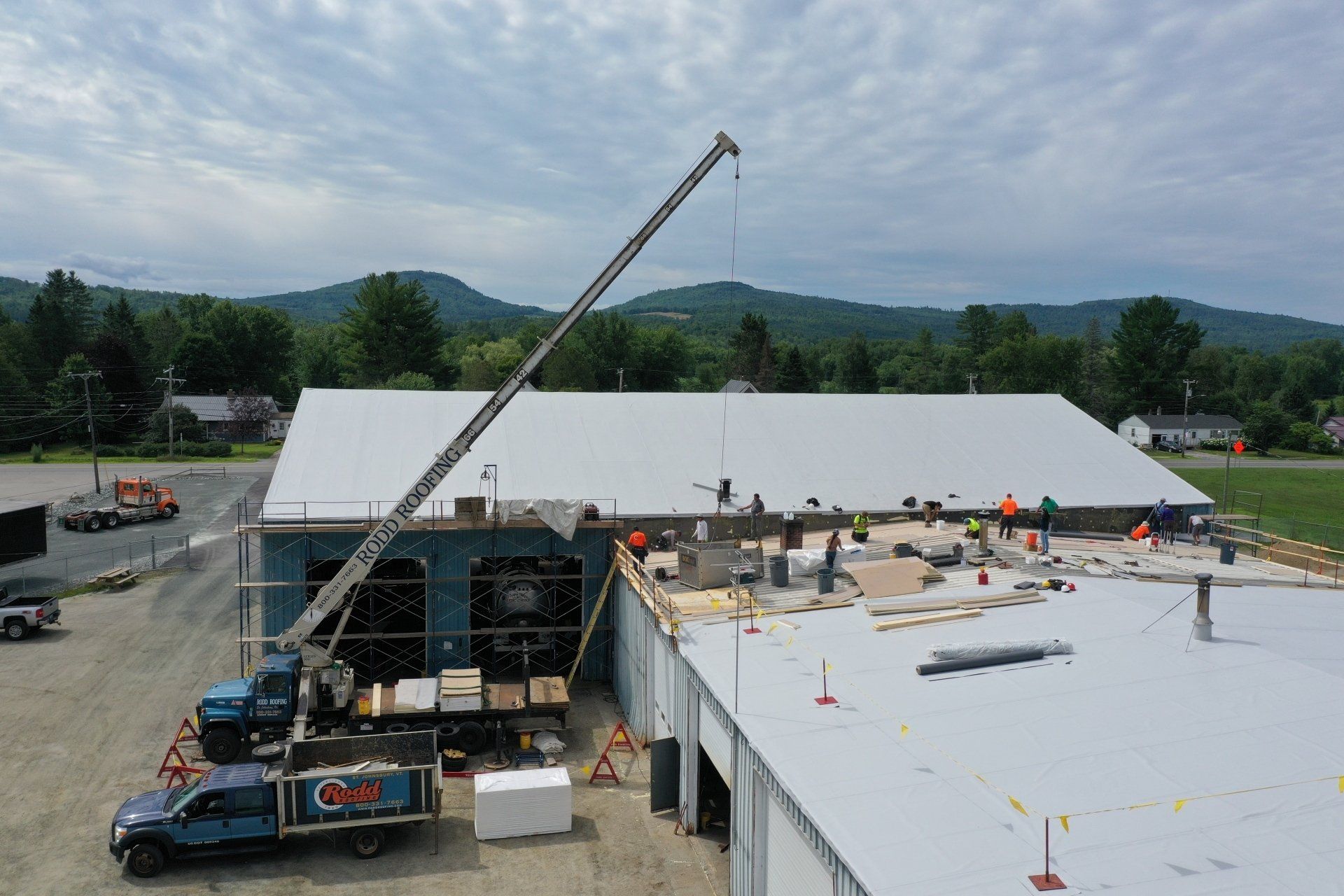 Metal Retrofit project, Rodd roofing employees on roof and with equipment