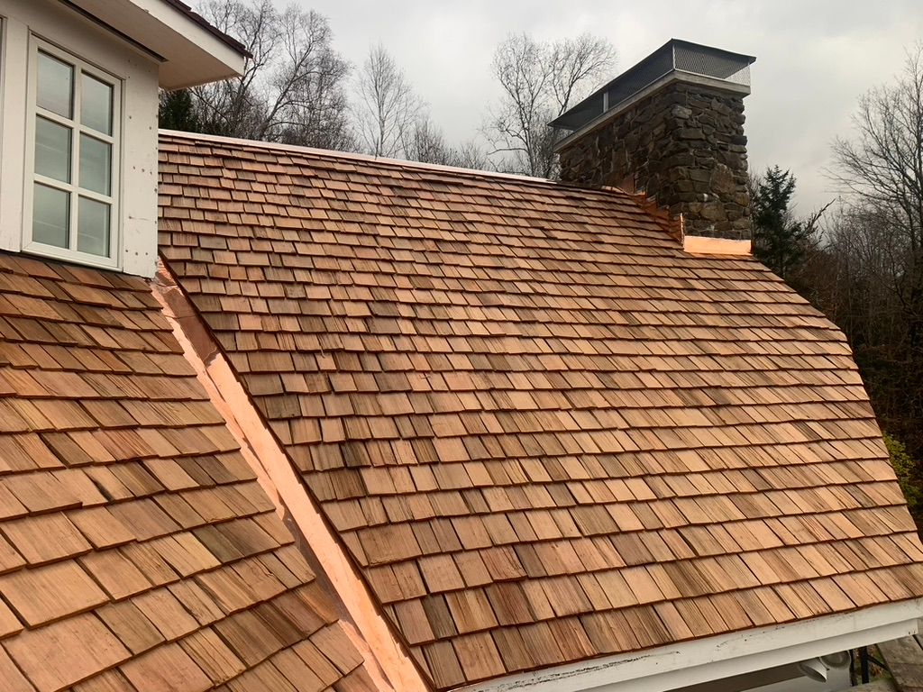 House with cedar shakes and copper flashing installed by Rodd Roofing  in Vermont