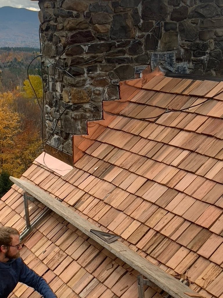 A man is standing on top of a wooden roof