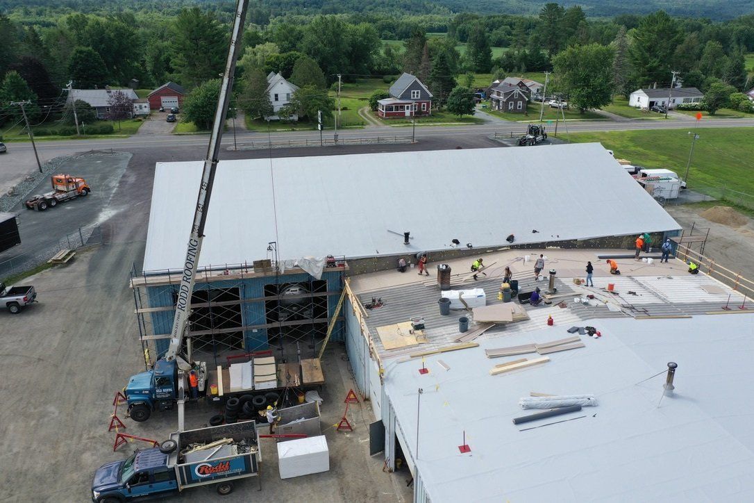 Metal Retrofit project, Rodd roofing employees on roof and with equipment
