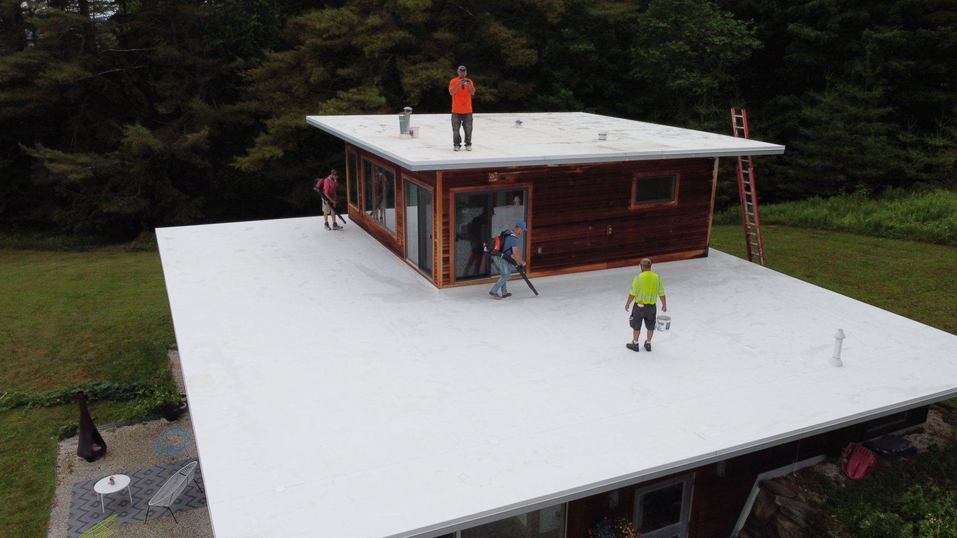 A group of people are standing on top of a white roof.