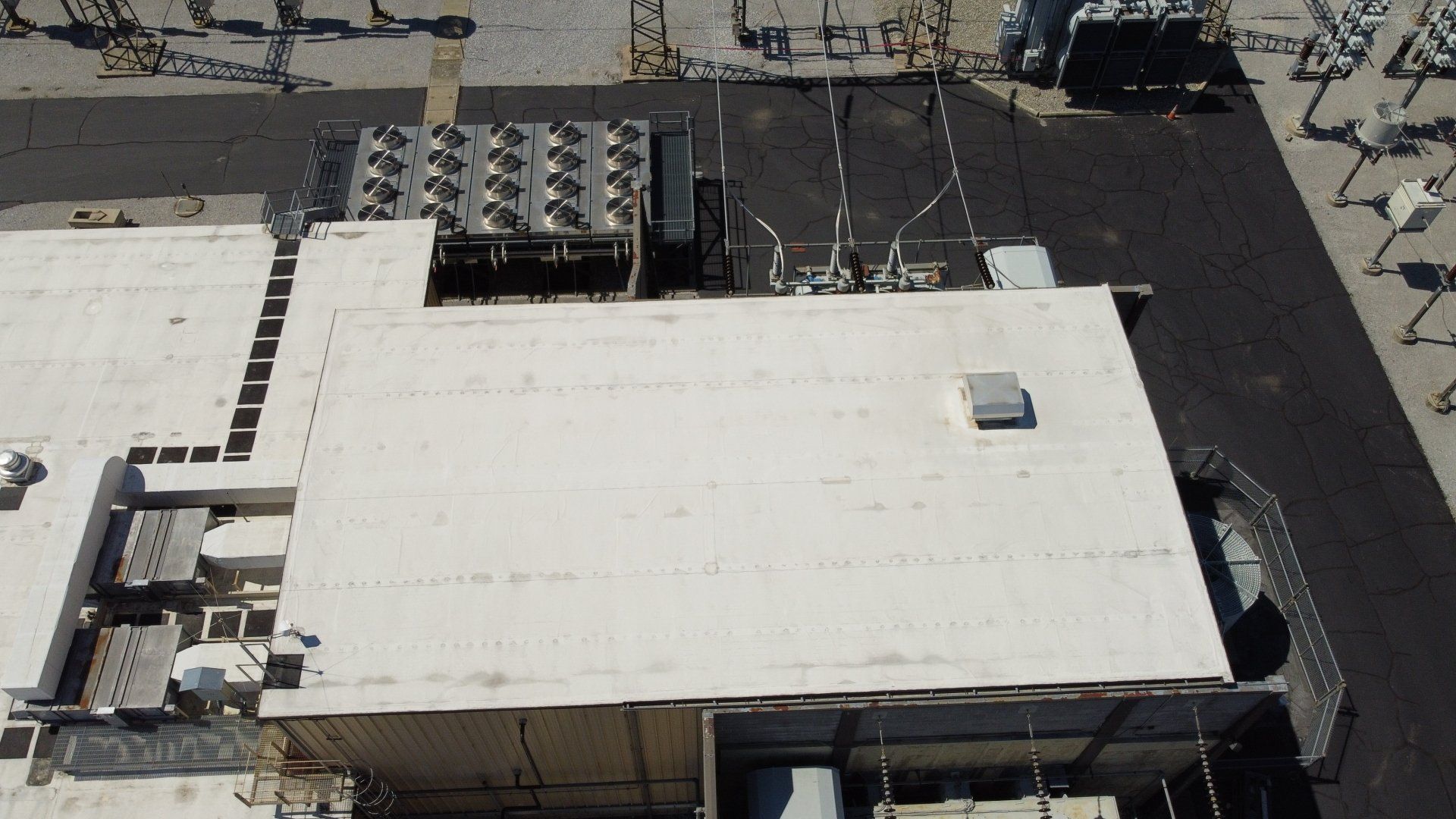 An aerial view of a large building with a white roof.