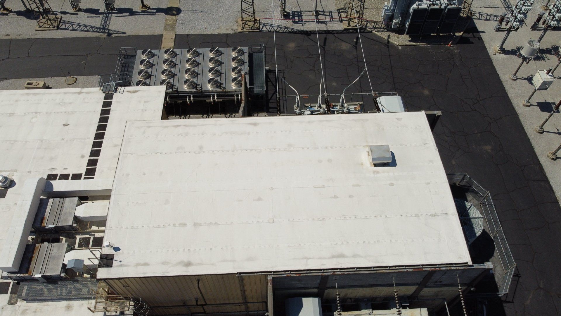 An aerial view of a large building with a white roof.